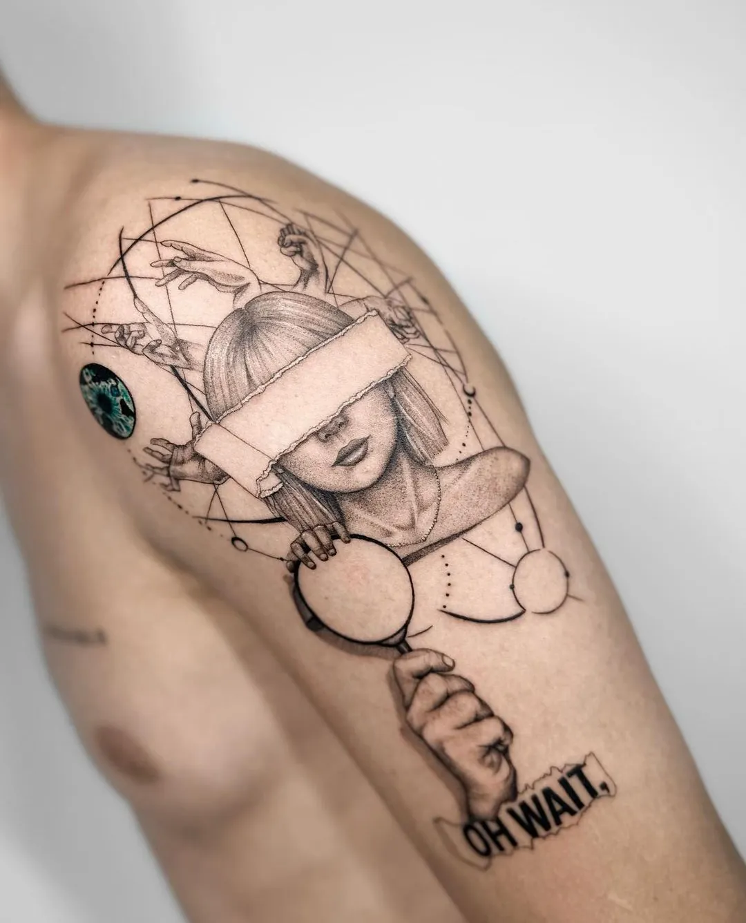 Tatuaj fine line pe umăr cu un portret suprarealist și text