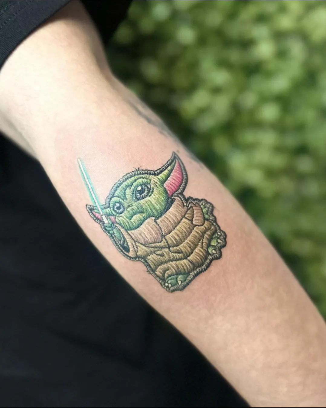 Tatuaj color pe braț cu un personaj verde din science fiction