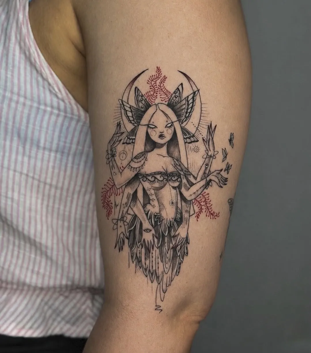 Tatuaj în stil schiță pe braț cu o zeiță înaripată, semilună și accente roșii