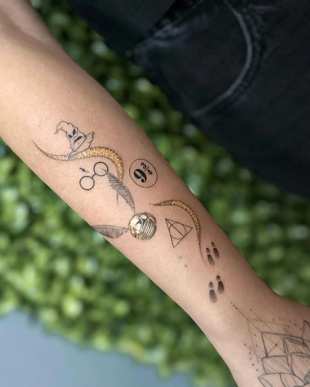 Tatuaje fine line pe braț cu simboluri magice și urme de lăbuțe